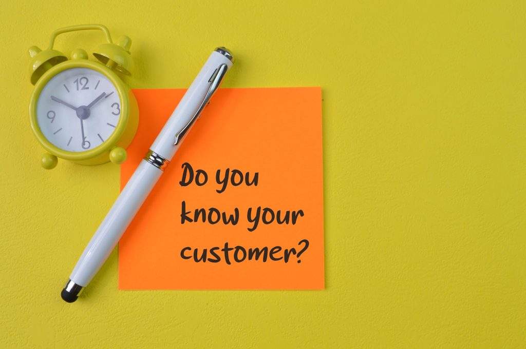 Clock, pen and memo note with question DO YOU KNOW YOUR CUSTOMER?